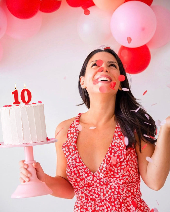 Jules celebrating Funkissd's 10th birthday with a 10 candle cake and confetti