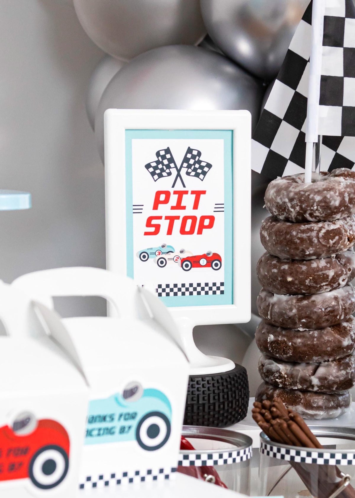 Pit Stop Vintage Race Car Sign - close-up of framed "Pit Stop" sign on a race car snack table with Spare Tires food label