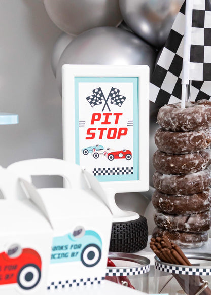 Pit Stop Vintage Race Car Sign - close-up of framed "Pit Stop" sign on a race car snack table with Spare Tires food label